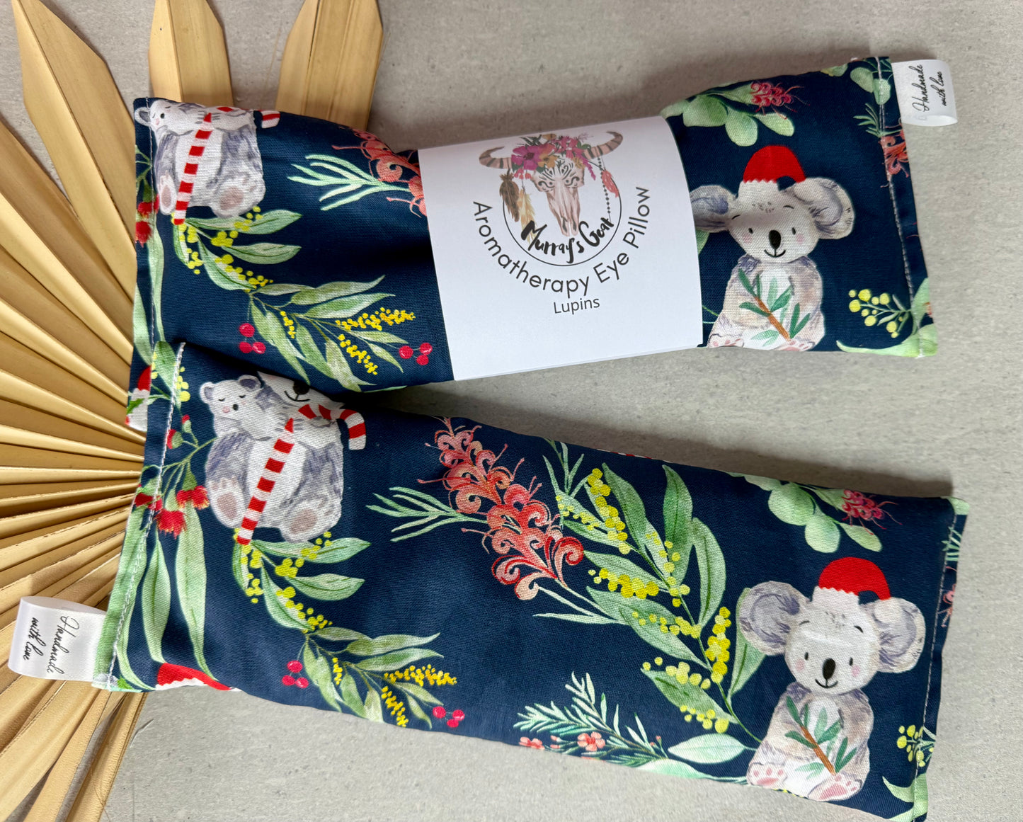Aromatherapy eye pillow with koala design and floral patterns on a neutral background